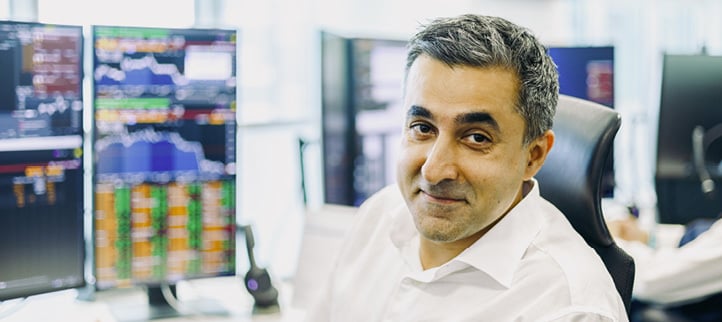 A Norges Bank Investment Management employee at the Singapore office, sitting in front of trading screens.