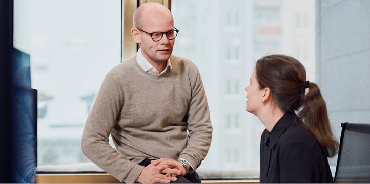 Two employees at Norges Bank Investment Management conversing in the office.