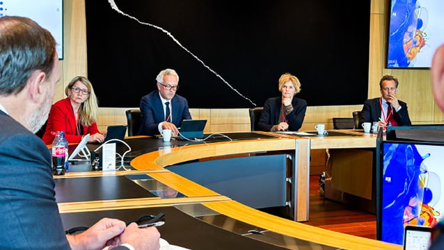 Two men and one woman in a meeting of the Climate Advisory Board.