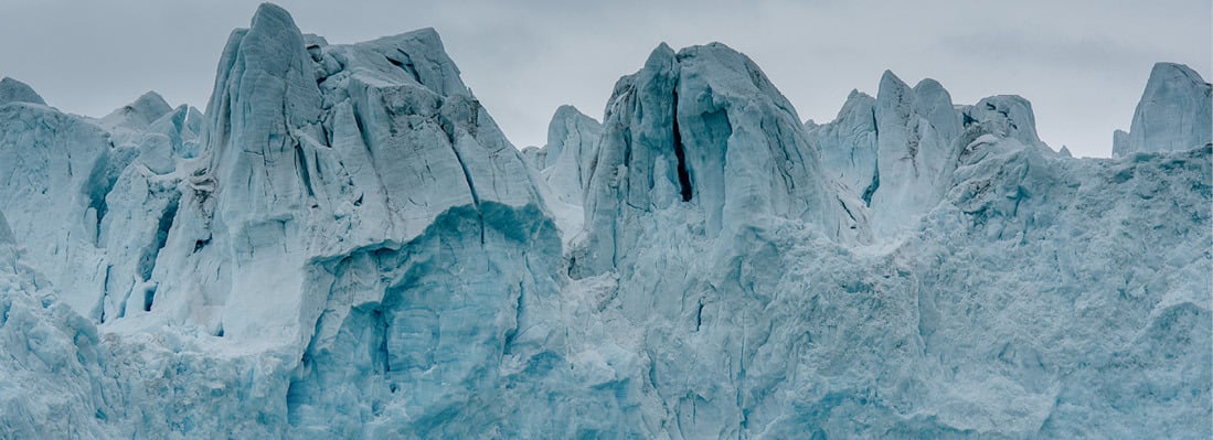 Close-up of a glacier wall with bluish ice formations.