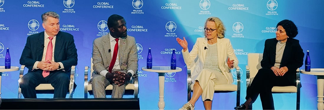 Four people in panel discussion at the Milken Institute Global Conference.