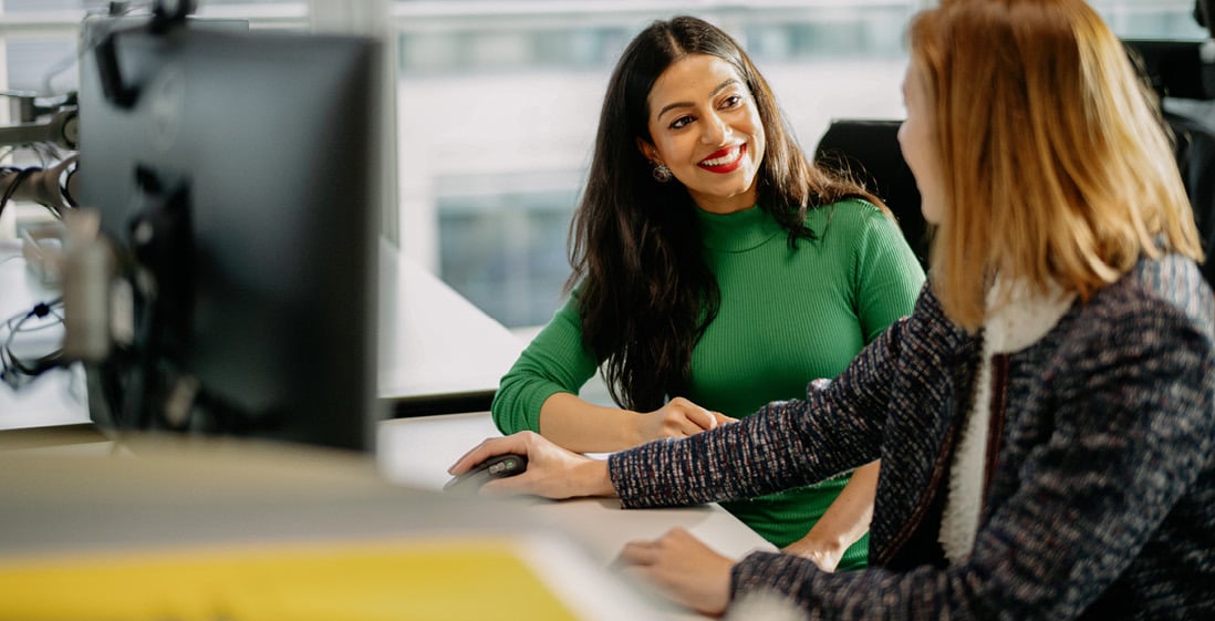 Two female employees at Norges Bank Investment Management talking in front of a computer.