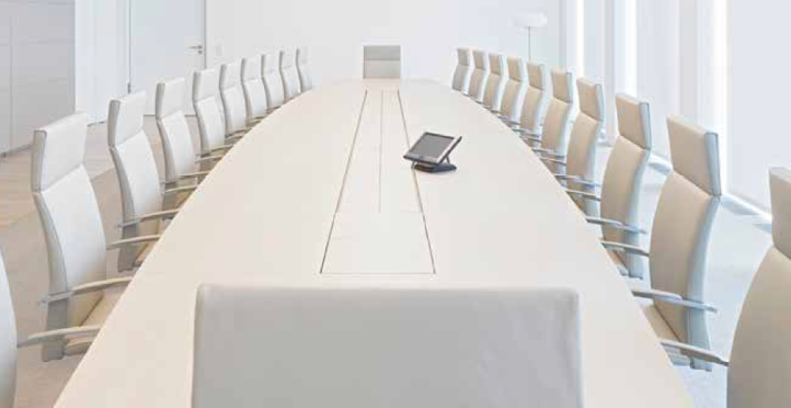 Empty meeting room with a long conference table and white chairs.